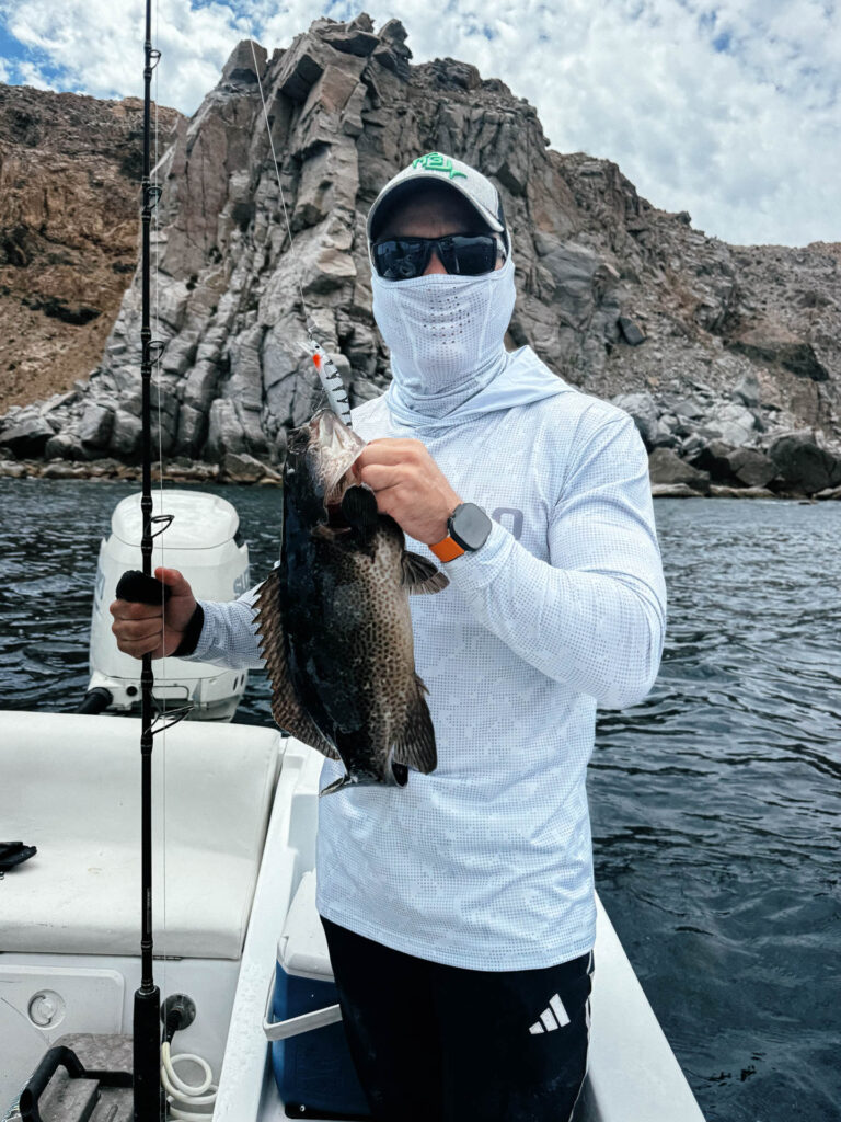 An angler displays a quality cabrilla caught near the rocky coastline and clear waters around Espiritu Santo Island.