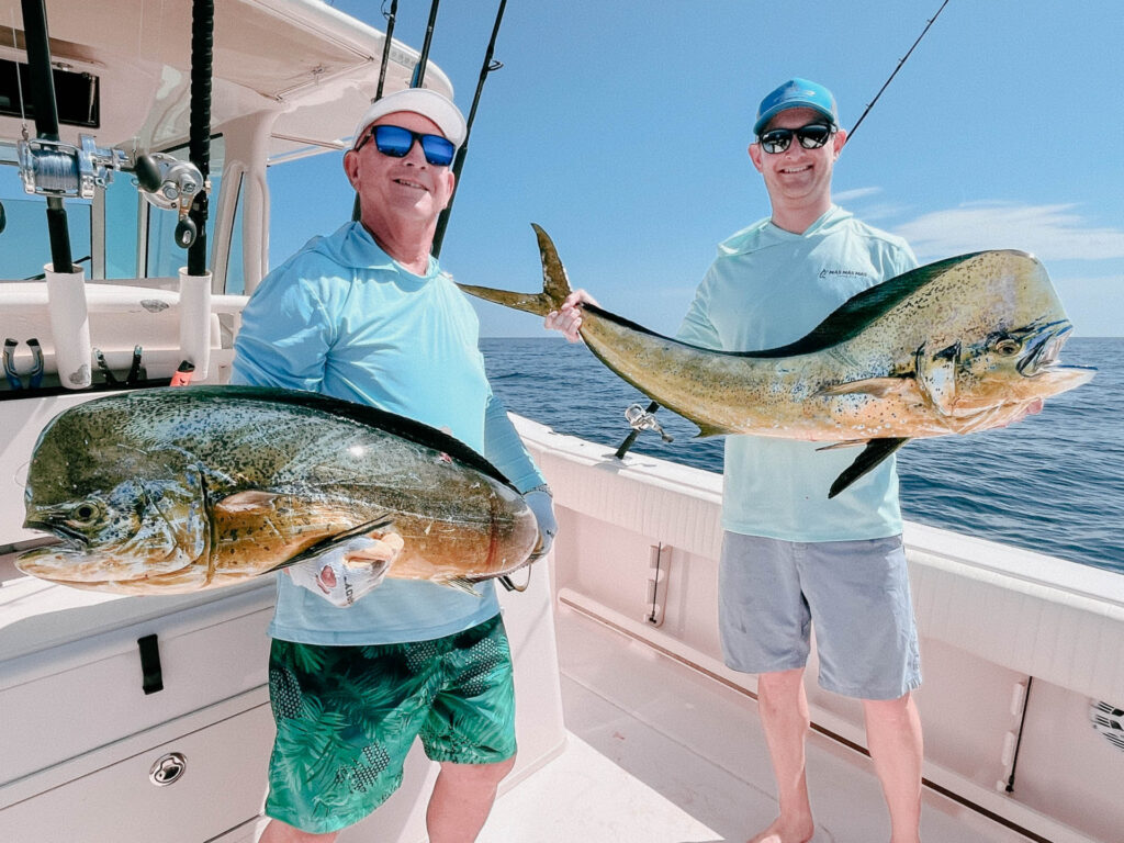 Two Anglers Each Holding a Dorado Offshore